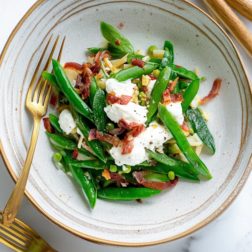 A plate of green beans with bacon on top.