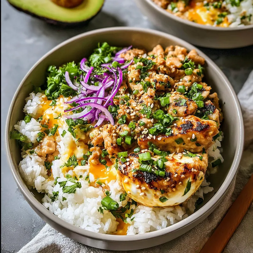 A bowl of food with chicken, rice, and avocado.