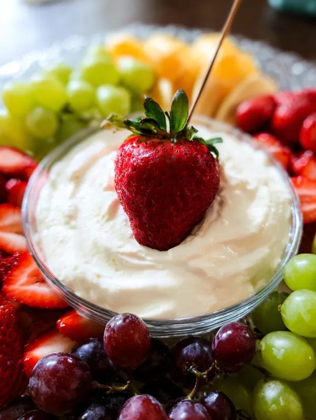 A bowl of cream cheese with a strawberry on top.