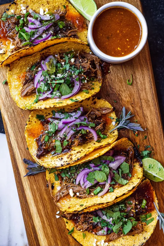 A plate of tacos with meat and onions.