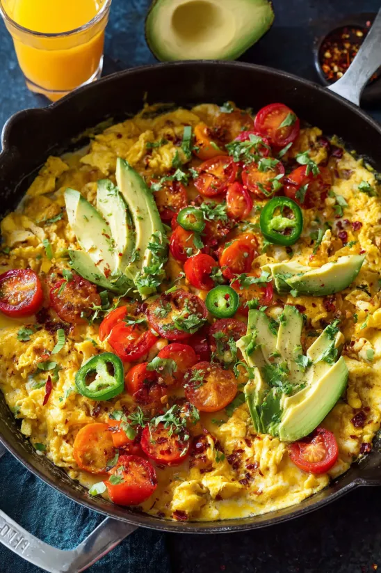 Migas with tomatoes, jalapenos, and avocado.