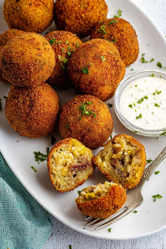 A plate of boudin balls with a dipping sauce.