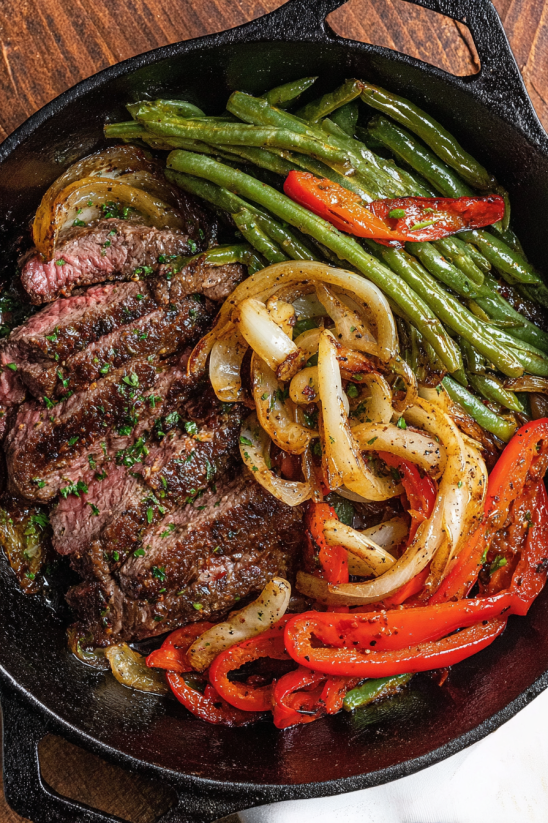 A delicious steak fajita meal with onions, peppers, and beans.
