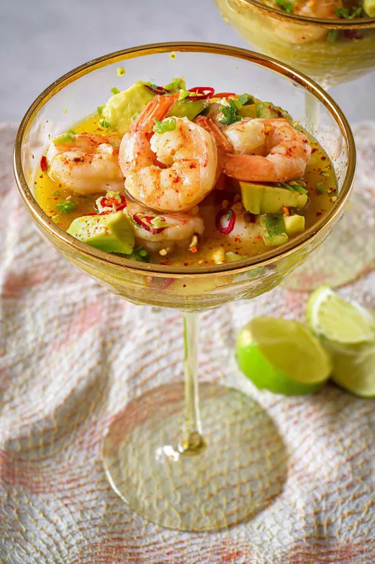A glass of shrimp cocktail with a slice of lime.