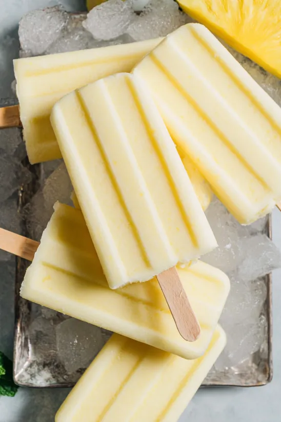 Dole Whip Popsicles are displayed on a table.