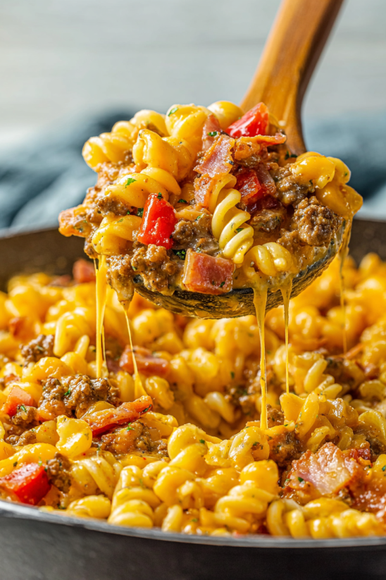 A spoon is filled with macaroni and cheese.