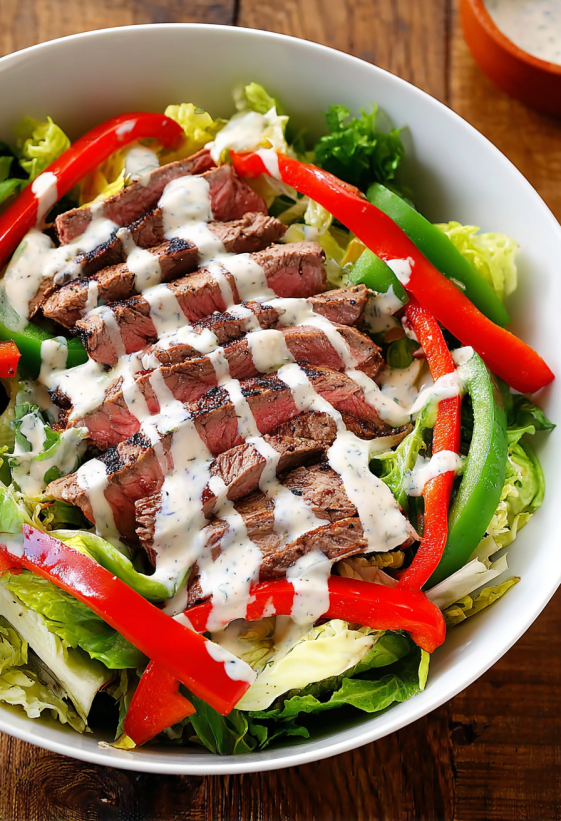 A bowl of steak fajita salad with chipsotle ranch dressing.