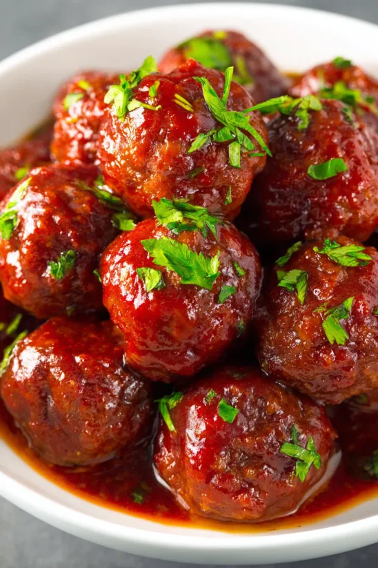 A plate of meatballs in a red sauce.