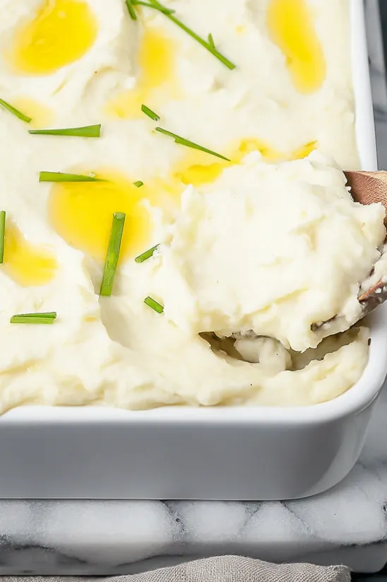 A white bowl filled with mashed potatoes.