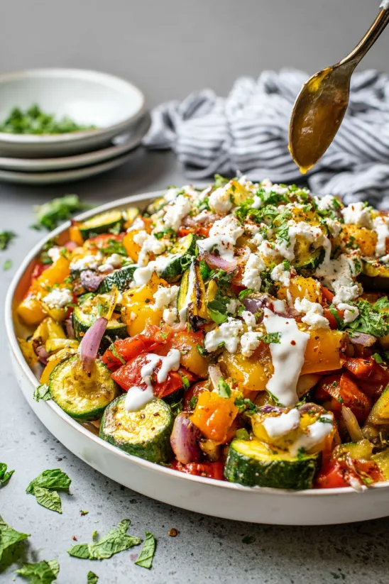 A dish of calabacitas with feta cheese and sour cream.