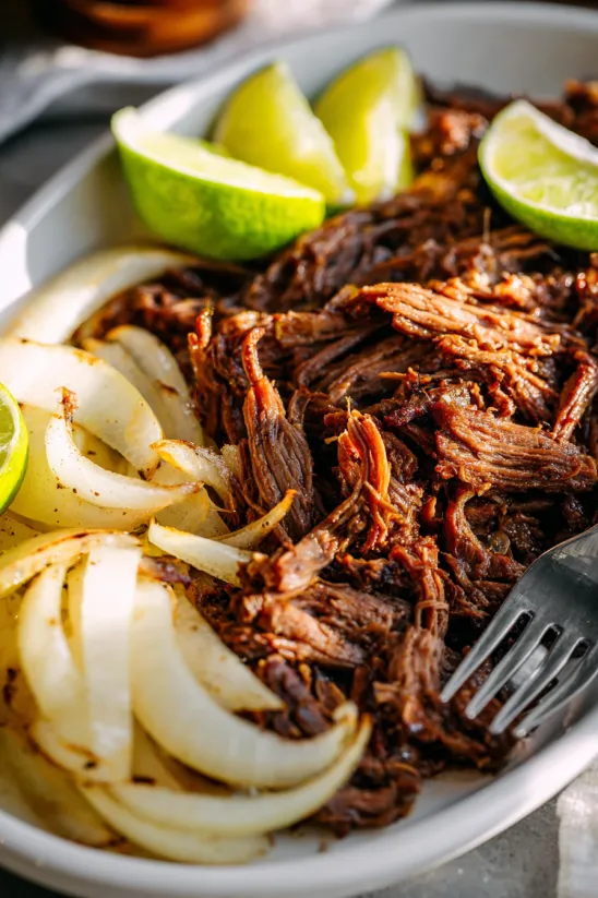 A plate of food with onions and limes.