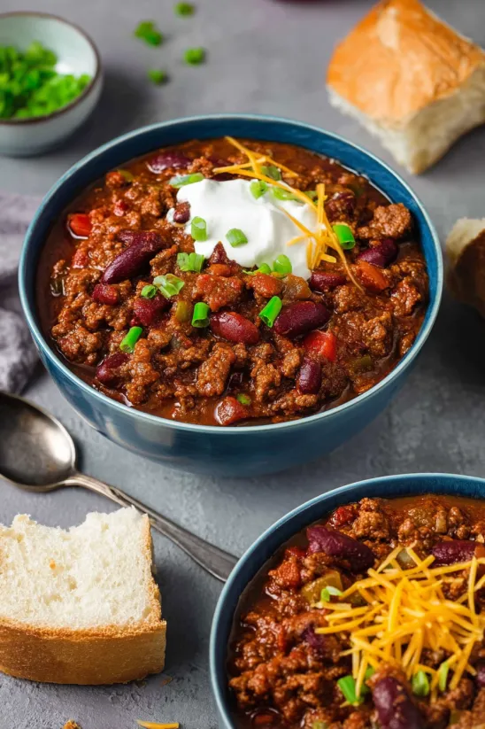 A bowl of chili with a spoon in it.