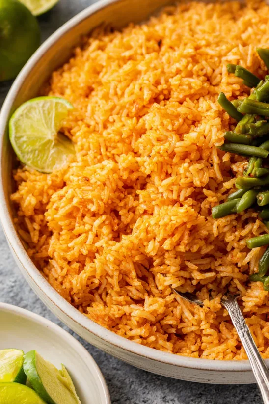 A bowl of rice with a lime wedge on top.