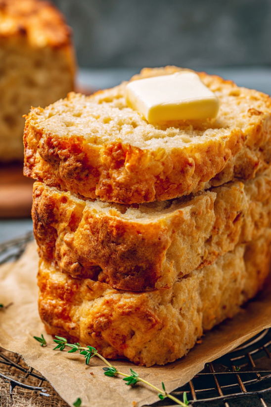 A stack of three loaves of bread with butter on top.