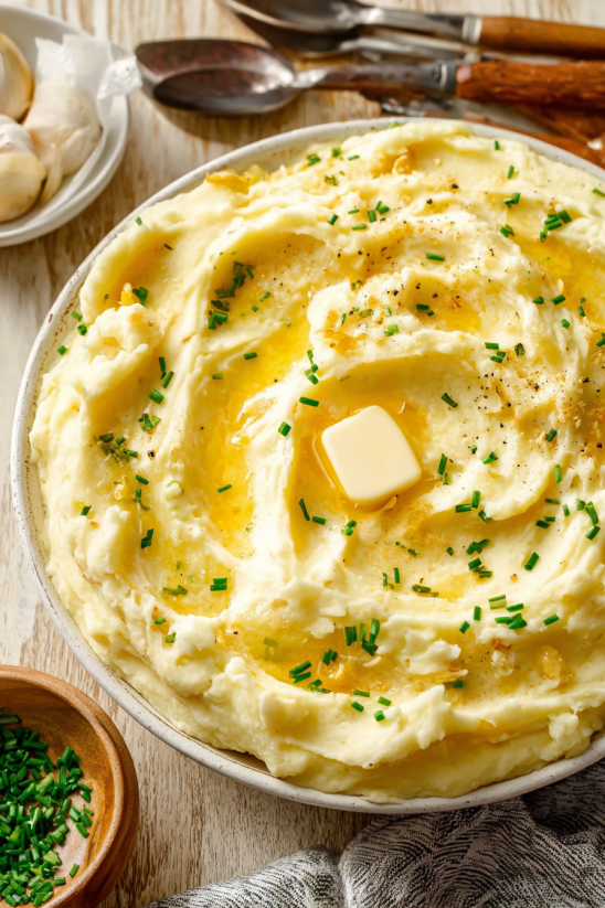 A dish of mashed potatoes with a butter on top.