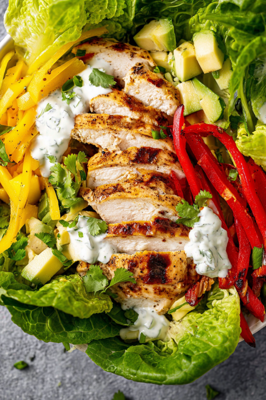 A salad with chicken and red peppers.