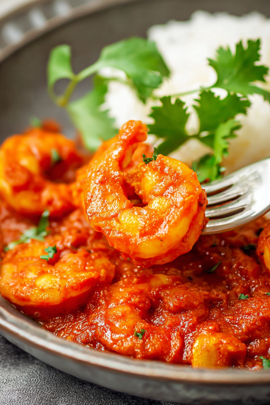 A plate of shrimp with a fork on it.