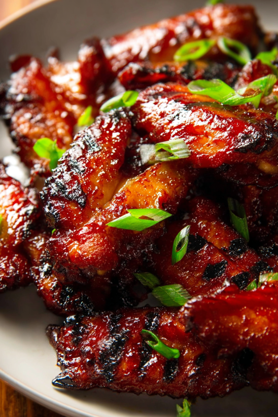 A plate of Chinese BBQ pork with green onions.