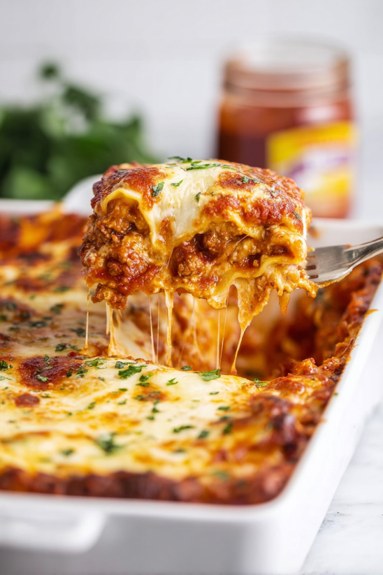 A slice of lasagna with cheese and herbs.