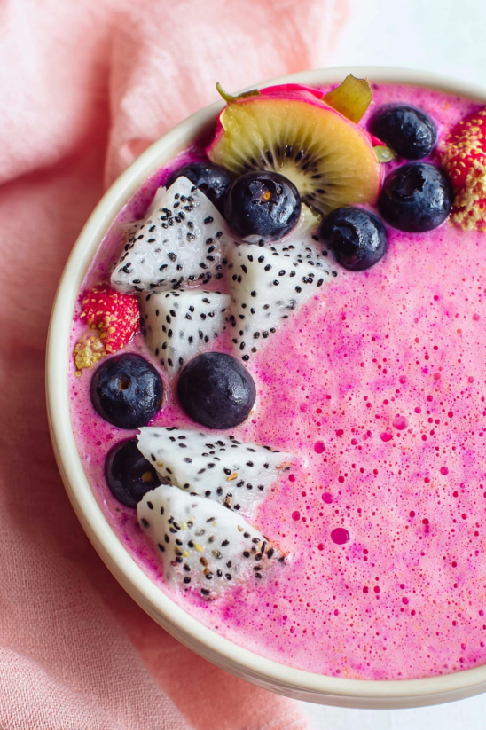 A bowl of fruit with strawberries and kiwi.