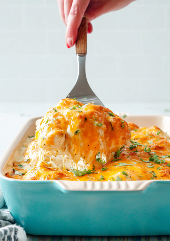 A fork is being used to cut into a cheese enchilada.