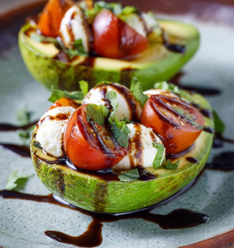 Caprese stuffed avocado with tomato and cheese.