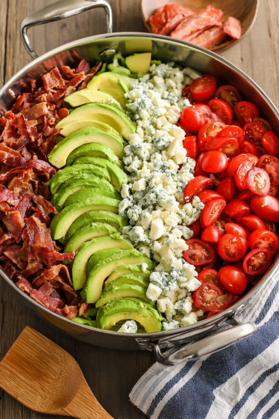 A pan of food with bacon, tomatoes, and cheese.
