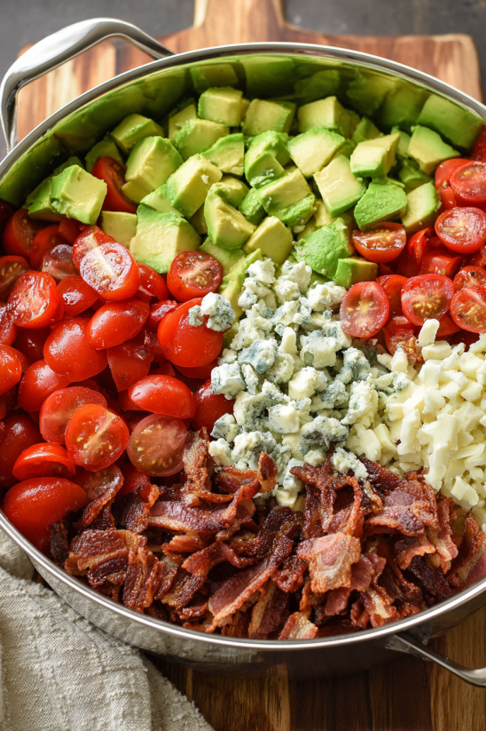 A bowl of food with tomatoes, avocado, and cheese.