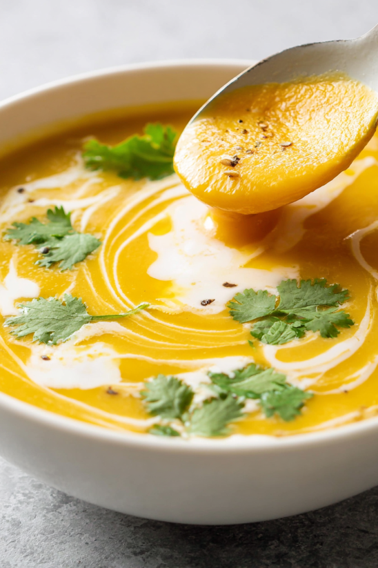A spoon is in a bowl of soup.