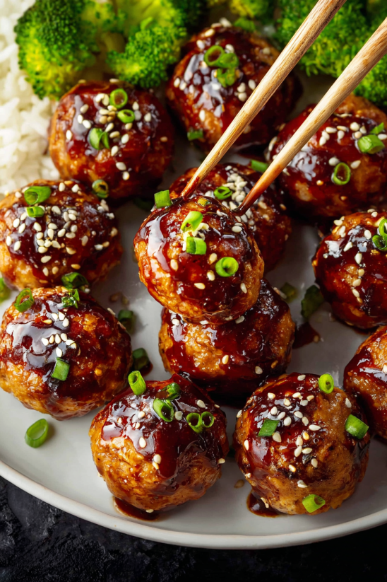 Asian chicken meatballs with sauce and green onions.