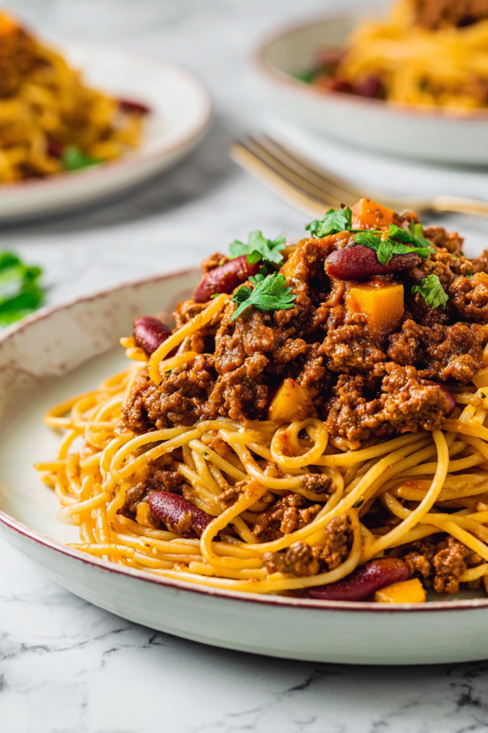 A plate of Mexican spaghetti with meat and vegetables.