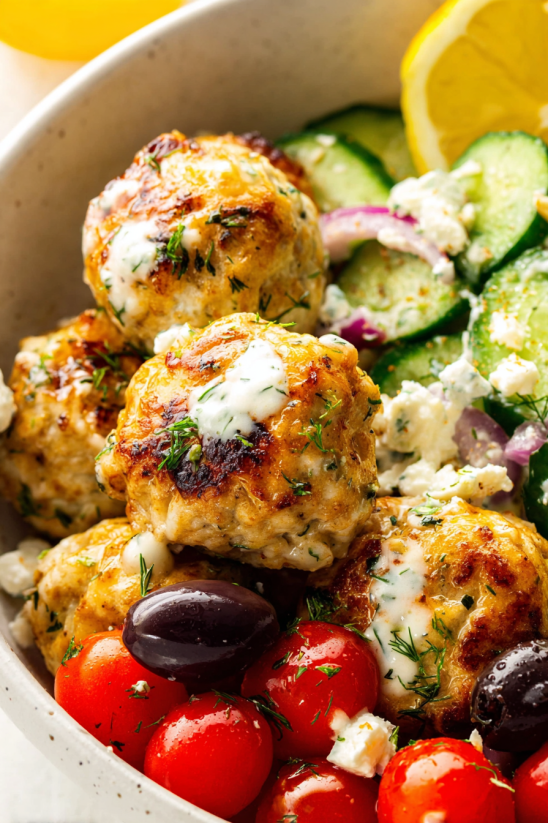 A bowl of Greek chicken meatballs with vegetables.