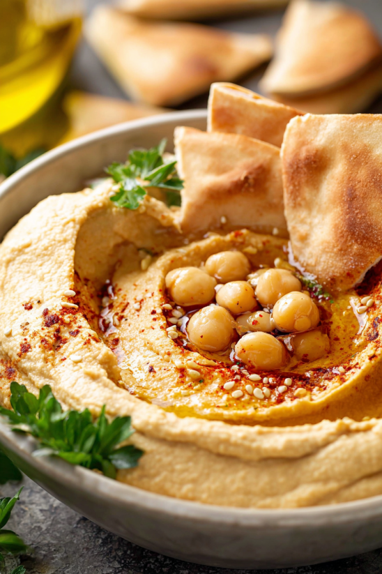 A bowl of hummus with chickpeas and tahini.