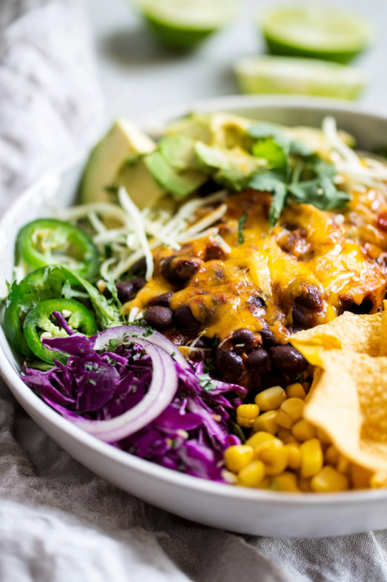 A bowl of food with a variety of ingredients including ground beef chili.