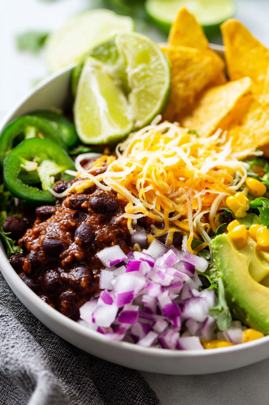 A bowl of food with a variety of ingredients including ground beef chili.