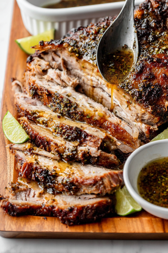 A delicious lechon asado with a spoonful of sauce.