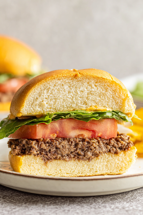 A sandwich with lettuce and tomato in a brioche bun.
