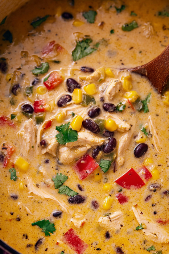 A bowl of chicken tortilla soup with a spoon in it.