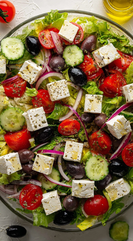 A Greek salad with tomatoes, cucumbers, olives, and feta cheese.