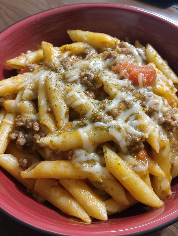 A bowl of pasta with cheese and meat.