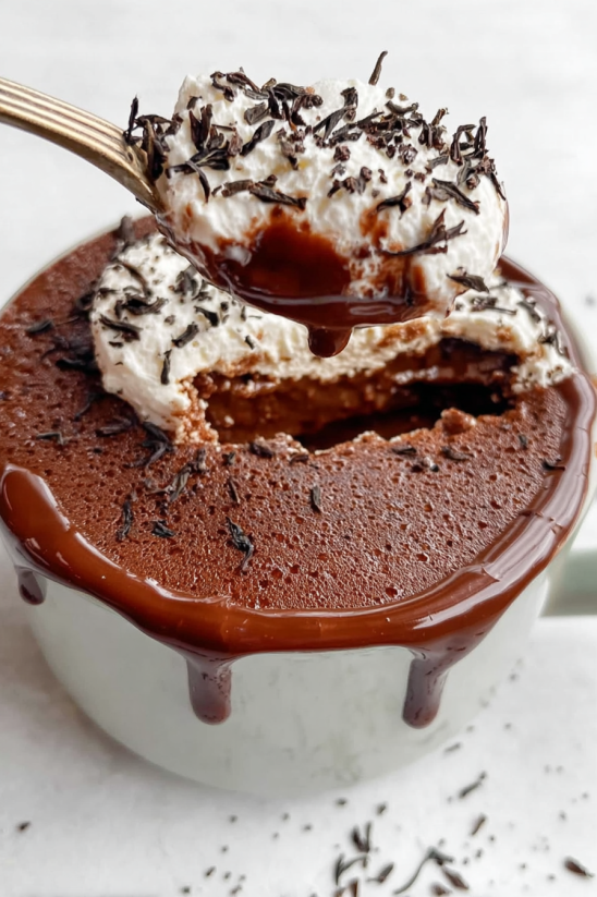 A cup of chocolate cake with a spoon in it.