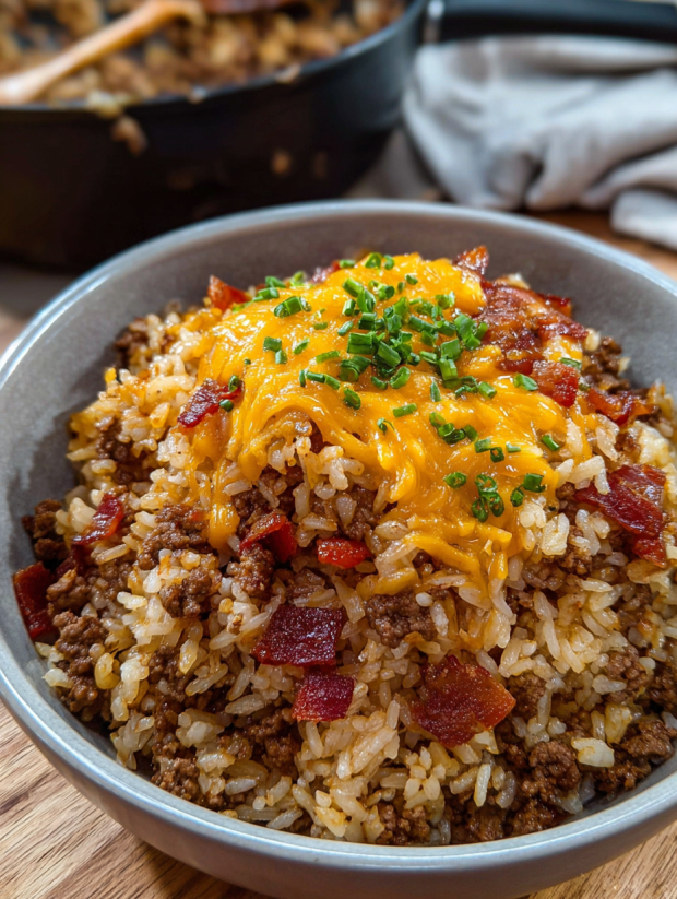 A bowl of rice with bacon and cheese on top.