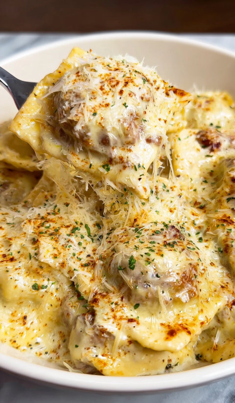 A close up of a delicious sausage Alfredo Ravioli Lasagna.