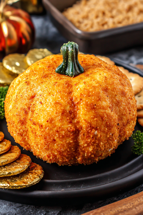A pumpkin cheese ball on a plate.