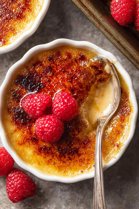 A bowl of French Creme Brûlée with a spoon in it.