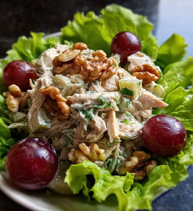 A plate of chicken salad with grapes and walnuts.