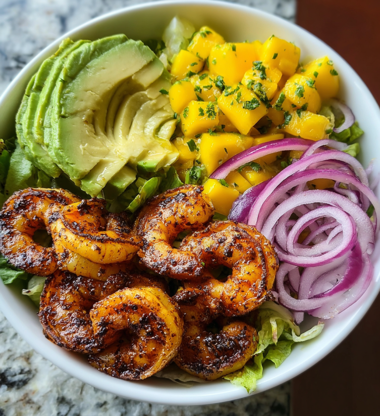 A bowl of shrimp, avocado, mango, and onion.