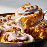 A fork is in a pan with a cinnamon roll.