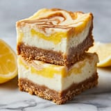 A stack of three lemon marbled cheesecake bars.